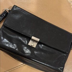 Black Messenger Bag with Sleek Design and Metallic Hardware